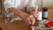 Elderly unrecognizable woman drinking a daily dose of pills with a glass of water. The hands of a person with arthritis