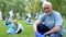 Elderly volunteer collecting plastic trash, looking at camera, eco event