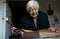 Elderly widowed woman holds photos of her deceased husband and gets emotional on valentine`s day remembering old times.