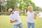 Elderly wife is angry and husband is shocked at the same time in park with green trees during summer time