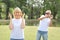 Elderly wife is angry and husband is shocked at the same time in park with green trees during summer time