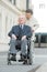 Elderly wife pushing husband on wheelchair