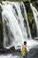 Elderly woman admiring the powerful waterfall