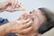 Elderly woman applying eye drops