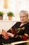 Elderly woman in armchair with book