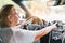 Elderly woman behind the steering wheel using her satnav