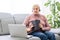 elderly Woman with bible and laptop in front of her connected to online church services durring the covid 19 outbreak