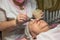 An elderly woman carries out a cosmetic procedure for the face.