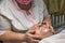 An elderly woman carries out a cosmetic procedure for the face.