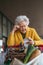 Elderly woman checking her receipt after purchase, looking at amount of money spent, ensuring all charges are correct.