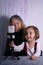 An elderly woman and a child are filming a video blog. Grandmother and granddaughter with a phone record video messages