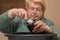 An elderly woman close-up pours compost into a seedling pot with a spatula.