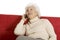 Elderly woman on the couch with mobile