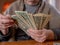 An elderly woman counts the remaining money. Economic crisis, poverty of the elderly.