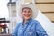 Elderly woman in cowboy hat, looking at camera and smiling. On open air.