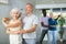 Elderly woman dancing merengue with male partner in latin dance class