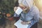 Elderly woman drinks from cup while reading