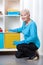 Elderly woman dusting shelves