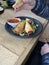 Elderly woman eating  patties rolls of dough stuffed with meat. Japanese or Chinese appetizer