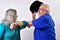 Elderly woman and elderly man doing the elbow bump