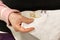 An elderly woman is embroidering a cross-stitch picture, hands close-up