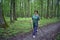 elderly woman is engaged in Nordic walking with sticks in the spring forest