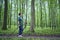 elderly woman is engaged in Nordic walking with sticks in the spring forest