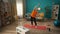 Elderly woman exercising in front of a laptop in the living room. A woman is watching a video tutorial on a laptop. A