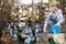 Elderly woman feeds domestic ducks on shore of man-made pond in the backyard of farm