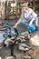 Elderly woman feeds domestic ducks on shore of man-made pond in the backyard of farm