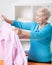 Elderly woman folding shirt