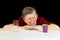 An elderly woman with gray hair and wrinkles on her face looks at the disposable plastic Cup with disgust and contempt. The