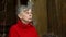 Elderly woman with grey hair is sitting on veranda of country house, portrait