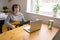 An elderly woman in headphones takes guitar lessons online. A retired senior woman studying online, watching music