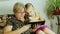 An elderly woman with her granddaughter playing together on a tablet. Communion of Generations