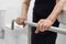 Elderly woman holding on handrail in toilet.