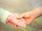 Elderly woman holding hands with young caregiver