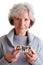 Elderly woman holding pill