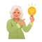 Elderly woman holds a light bulb in her hand. Old lady has an idea. Portrait of a happy pensioner. Smart white granny with an idea