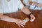 Elderly woman holds pills and ampoule. Close-up of pensioner`s hands with drugs. Young woman unpacks the syringe