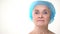 Elderly woman in hygienic cap before cosmetology procedures, plastic surgery