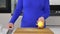 An elderly woman in the kitchen makes lemonade from fruits, cutting and tossing citrus fruits, special effects, selective focus. I