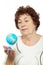 Elderly woman looks at small globe