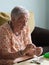 Elderly woman making necklaces