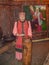 An elderly woman in national costume conducts a tour of the museum.