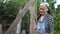 An elderly woman opens a wooden door to the barn. Third World countries, poor rural life