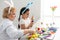 Elderly woman pains Easter egg yellow colour. Family preparing for Easter. Close-up hands with egg