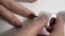 An elderly woman paints her nails with nail polish. Close-up on the fingers. White background