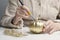 An elderly woman paints a pumpkin. Lifestyle pensioners. Old hands paint pumpkin with gold paint with brush