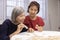 Elderly woman playing alphabet games for improve mental health and memory with daughter